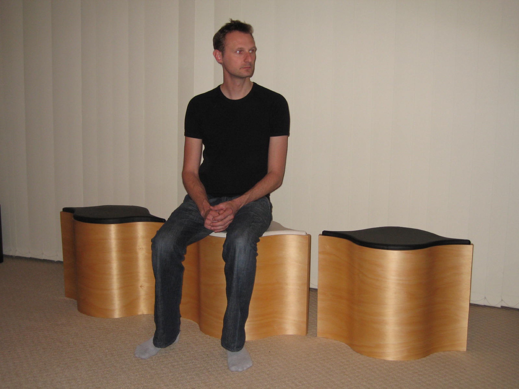 A person seated across three light-timber Flosion modules, showing the furniture at human scale